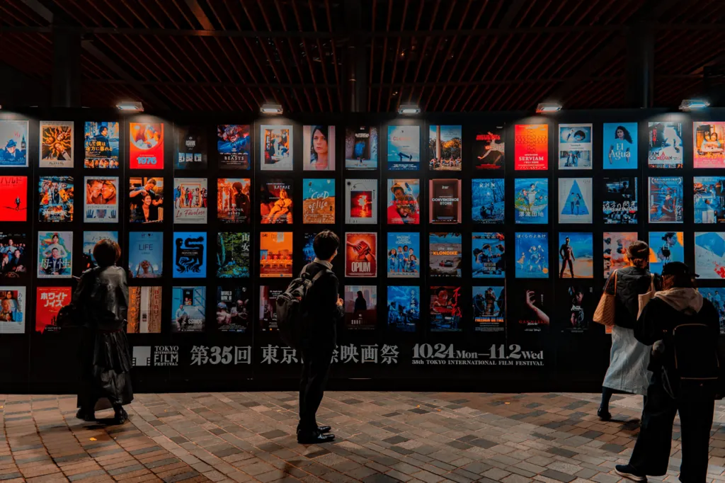 People look at a wall of film posters at the 35th Tokyo International Film Festival.