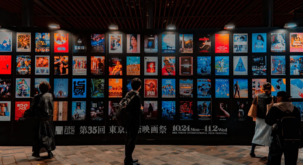 People look at a wall of film posters at the 35th Tokyo International Film Festival.